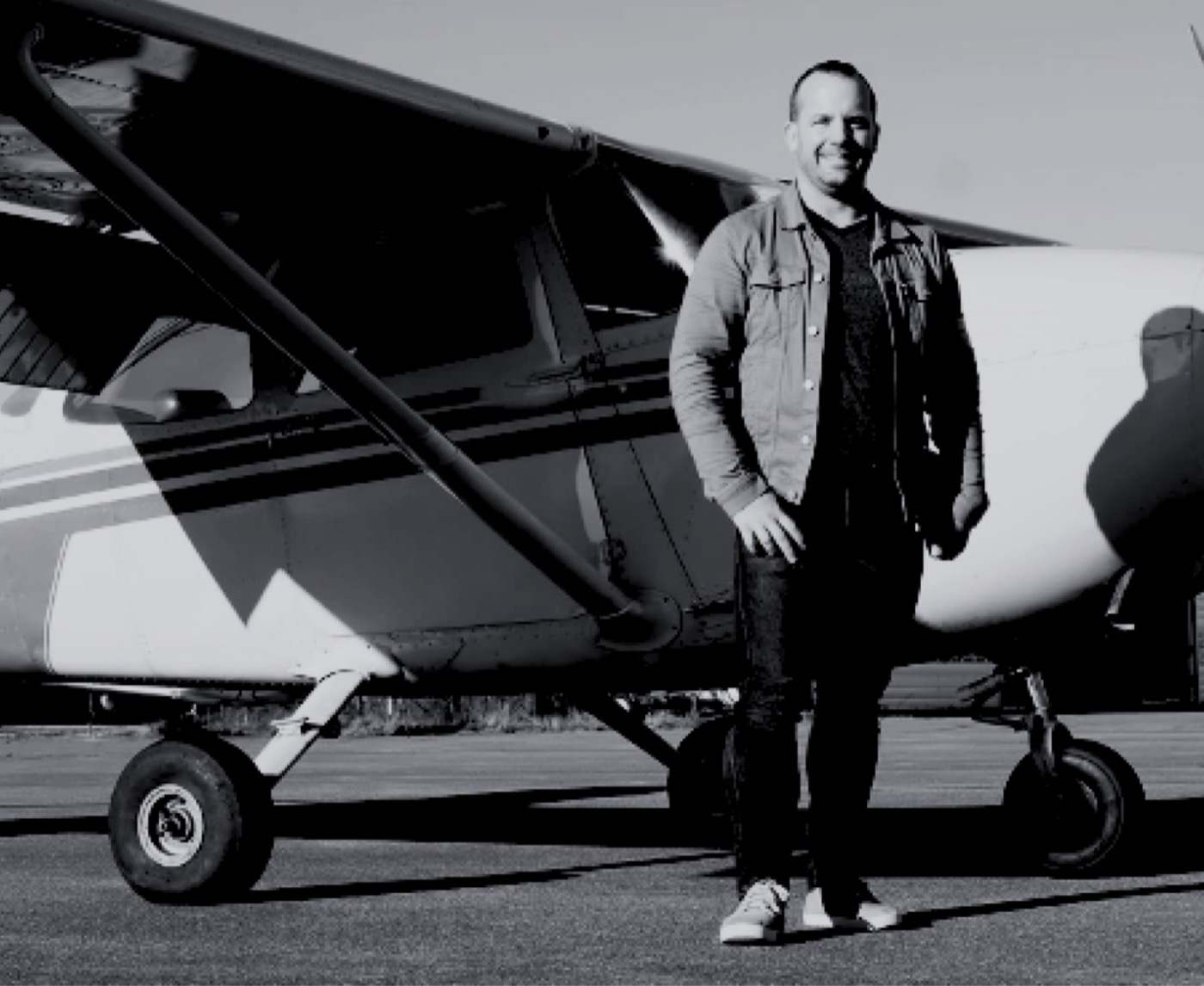 Ashley standing beside a small propeller plane